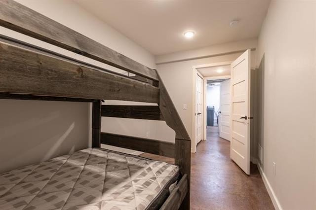 bedroom with concrete flooring and baseboards