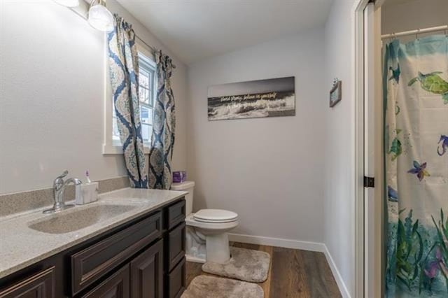 full bathroom featuring toilet, wood finished floors, baseboards, vanity, and vaulted ceiling