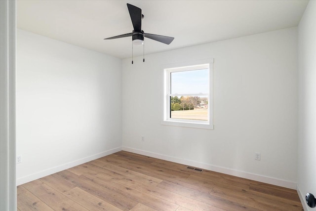 empty room featuring ceiling fan, visible vents, baseboards, and light wood-style flooring