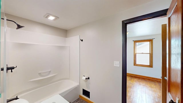 bathroom featuring visible vents, shower / tub combination, baseboards, and hardwood / wood-style floors