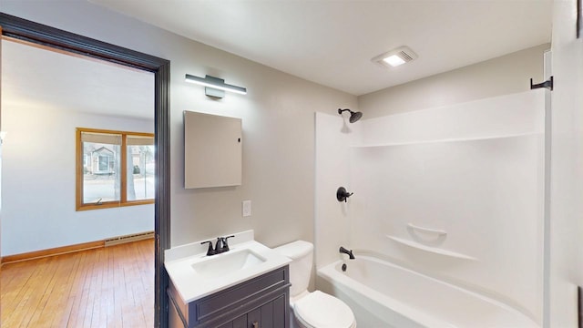 full bathroom featuring toilet, a baseboard heating unit, hardwood / wood-style floors, bathtub / shower combination, and vanity