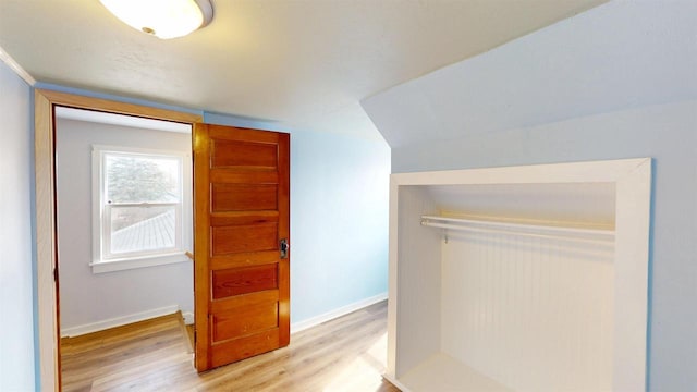 bonus room featuring light wood-style flooring and baseboards