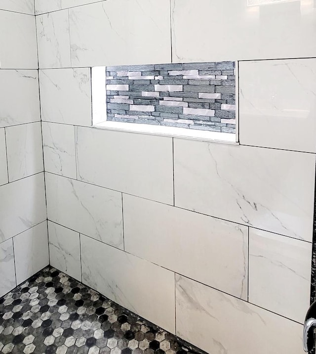 interior details featuring a tile shower