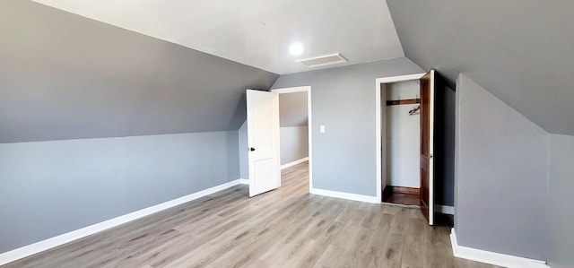 bonus room with vaulted ceiling, baseboards, and light wood-type flooring