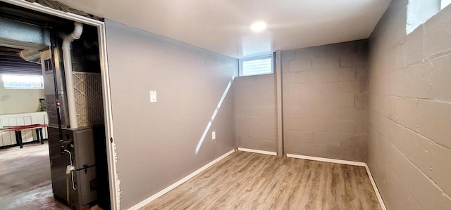 basement with concrete block wall and wood finished floors