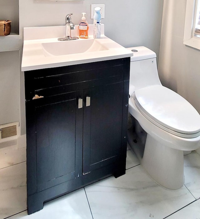 half bathroom with visible vents, toilet, marble finish floor, and vanity