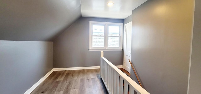 additional living space featuring vaulted ceiling, baseboards, and wood finished floors