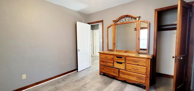 bedroom featuring baseboards and light wood finished floors