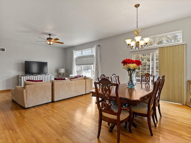 dining room featuring visible vents, ceiling fan with notable chandelier, light wood-type flooring, and baseboards