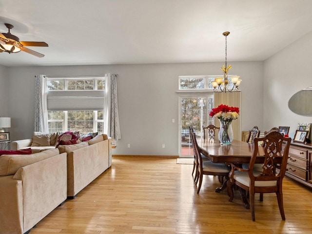 dining room featuring ceiling fan with notable chandelier, baseboards, and light wood-style floors