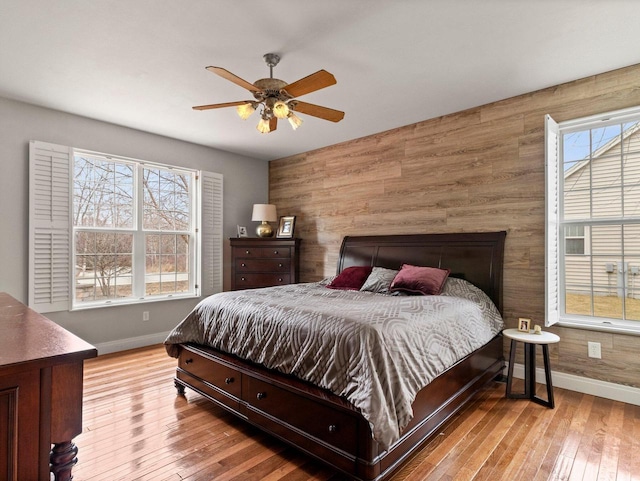 bedroom featuring multiple windows, baseboards, and hardwood / wood-style floors