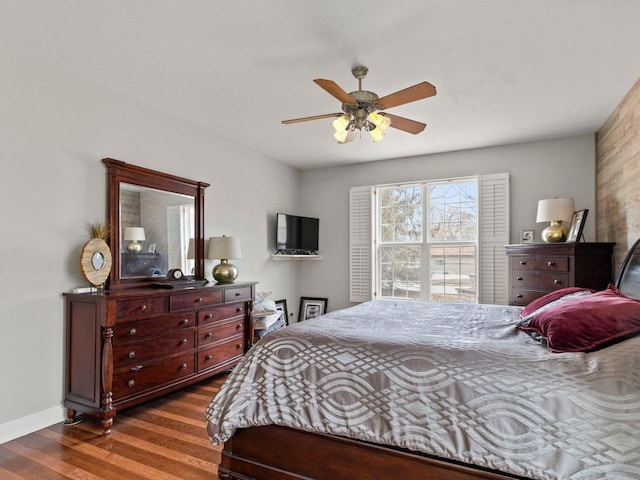 bedroom with ceiling fan, baseboards, and wood finished floors