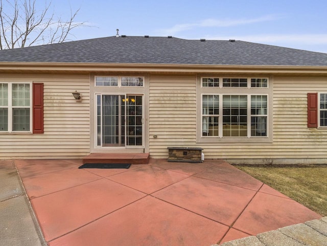 back of house featuring roof with shingles and a patio area