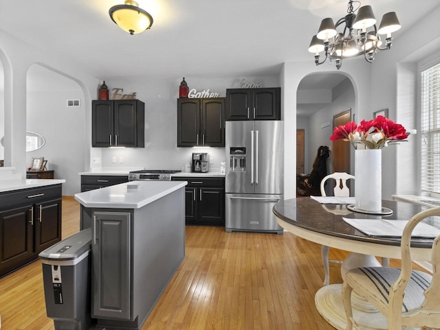 kitchen featuring visible vents, arched walkways, light countertops, appliances with stainless steel finishes, and light wood-type flooring