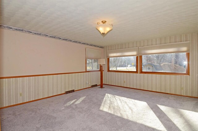 5511 Maywood Rd, Monona, WI 53716 - carpeted empty room featuring wallpapered walls, baseboards, and visible vents