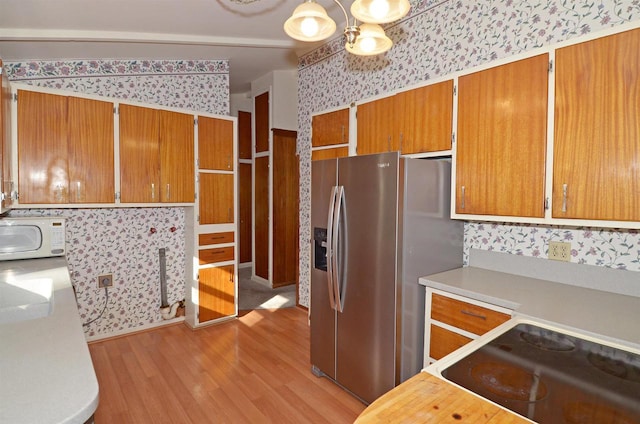 5511 Maywood Rd, Monona, WI 53716 - kitchen with stainless steel fridge, white microwave, light countertops, and wallpapered walls