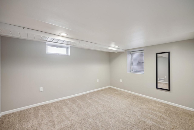 carpeted empty room featuring visible vents and baseboards