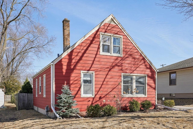 back of property featuring a chimney and fence