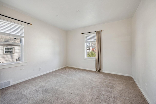 carpeted empty room with visible vents and baseboards