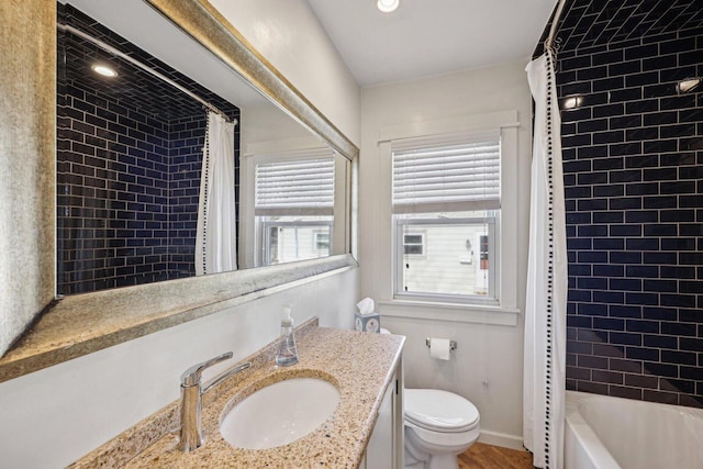 full bath featuring baseboards, shower / bath combo with shower curtain, toilet, wood finished floors, and vanity