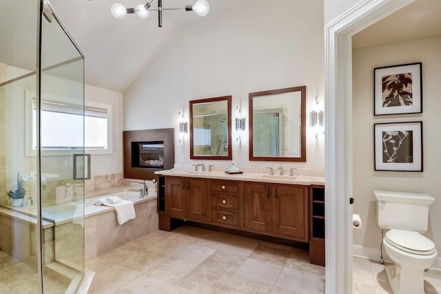 bathroom featuring double vanity, a stall shower, a sink, a garden tub, and toilet