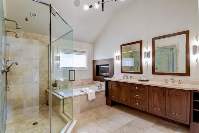 bathroom with a sink, a shower stall, double vanity, a bath, and vaulted ceiling