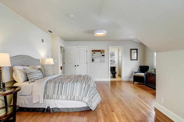 bedroom featuring visible vents, baseboards, and wood finished floors