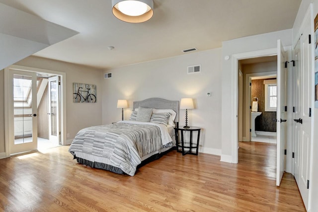 bedroom with baseboards, visible vents, and light wood-type flooring