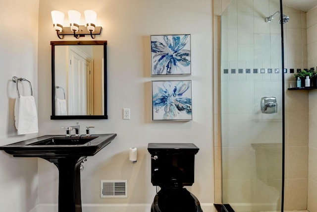 bathroom with a tile shower and visible vents