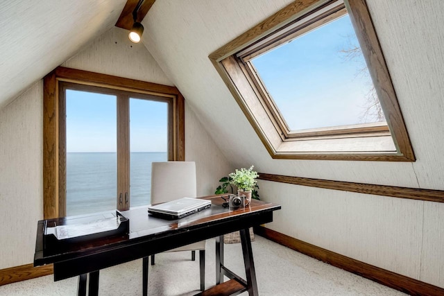 office with baseboards, vaulted ceiling with skylight, light carpet, and a water view