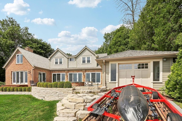 back of house with a yard, brick siding, and a chimney