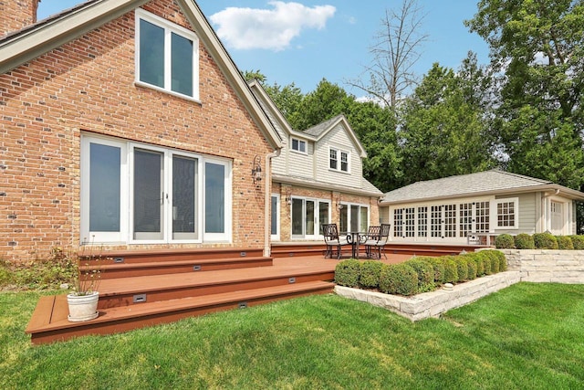 back of house featuring a lawn, entry steps, french doors, a wooden deck, and brick siding