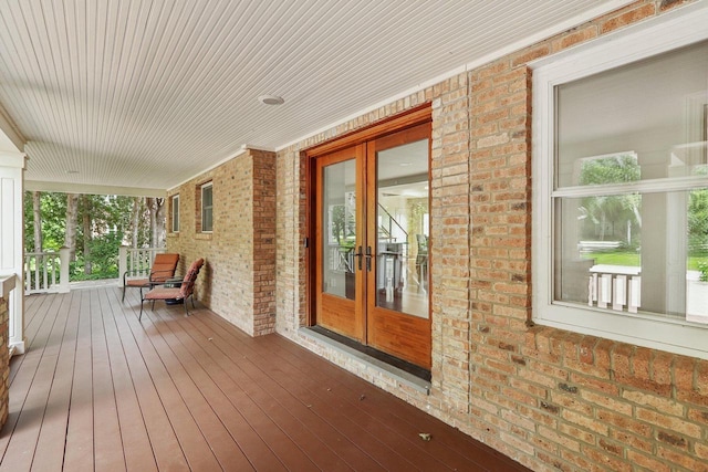 wooden deck featuring a porch and french doors