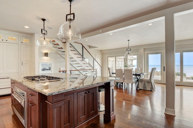 kitchen featuring dark wood finished floors, light stone countertops, white cabinetry, and stainless steel gas cooktop