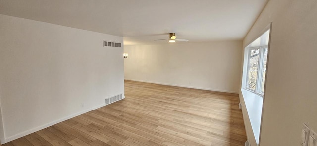 spare room featuring visible vents, baseboards, light wood-style flooring, and a ceiling fan