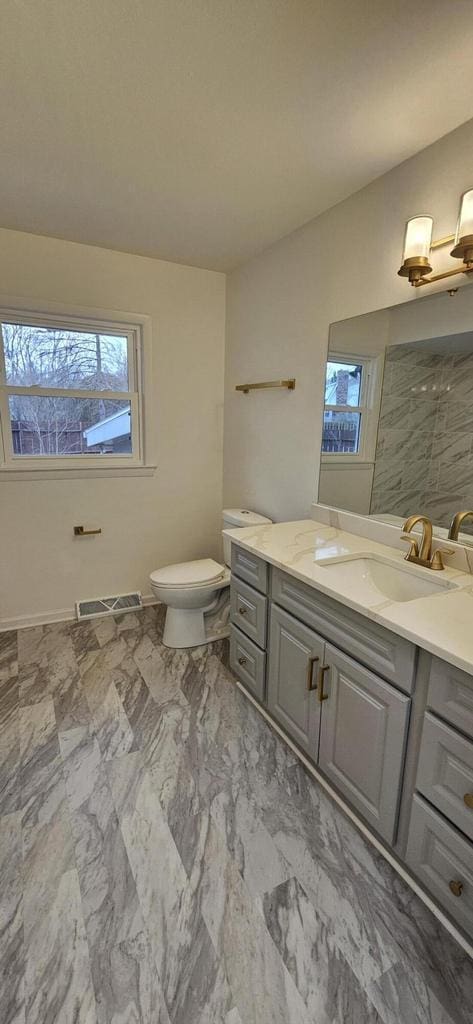 bathroom featuring visible vents, plenty of natural light, toilet, and marble finish floor