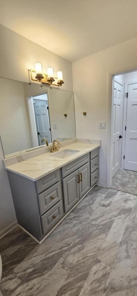 bathroom with vanity, baseboards, and marble finish floor