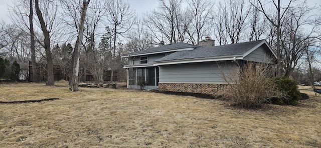 view of side of property with a chimney and a yard