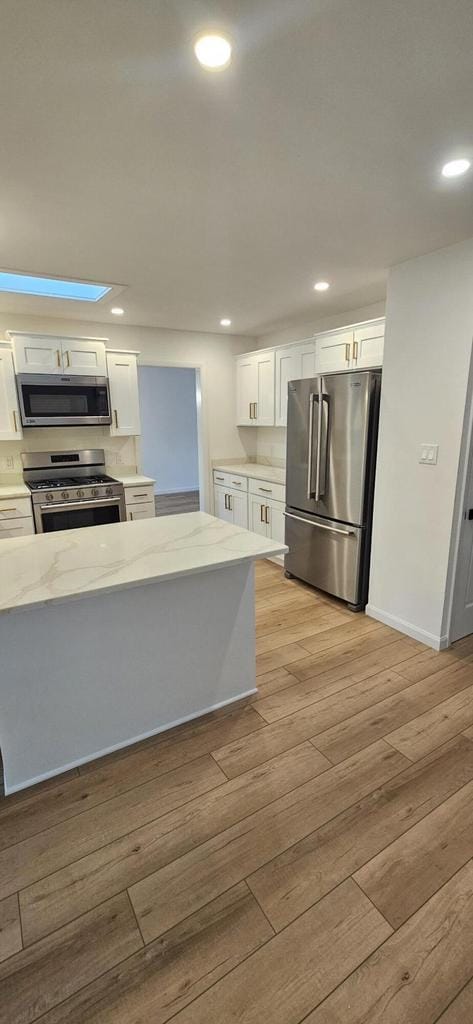 kitchen with light wood-style flooring, recessed lighting, white cabinets, and appliances with stainless steel finishes