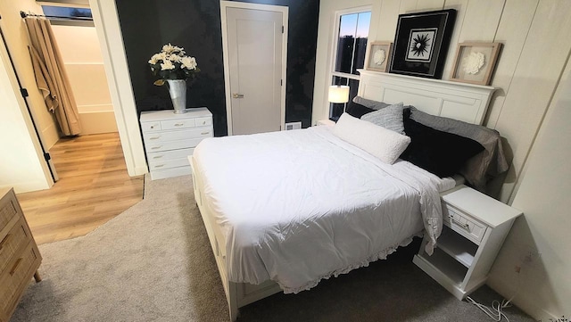 bedroom with light wood-type flooring and light carpet