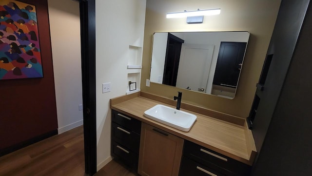 bathroom featuring vanity, baseboards, and wood finished floors