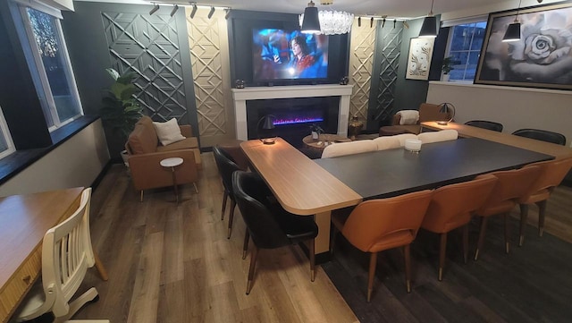 dining room featuring a glass covered fireplace and wood finished floors