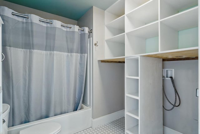 bathroom with tile patterned floors, baseboards, toilet, and shower / bath combo