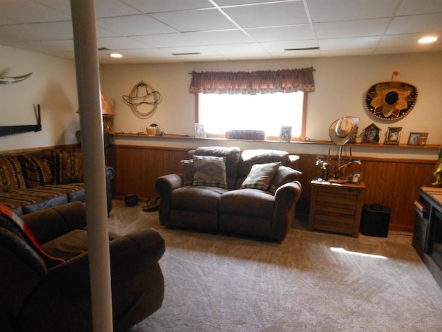 living room with a wainscoted wall, a paneled ceiling, wood walls, and carpet flooring