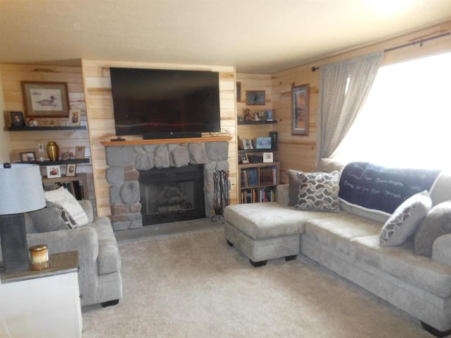 carpeted living room featuring wooden walls and a stone fireplace