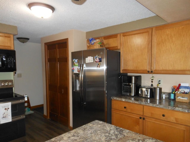 kitchen with brown cabinets, a textured ceiling, appliances with stainless steel finishes, stone counters, and dark wood-style flooring