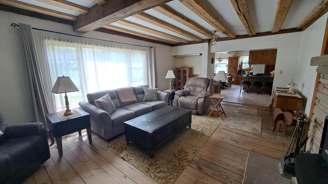 living area with beamed ceiling and wood-type flooring