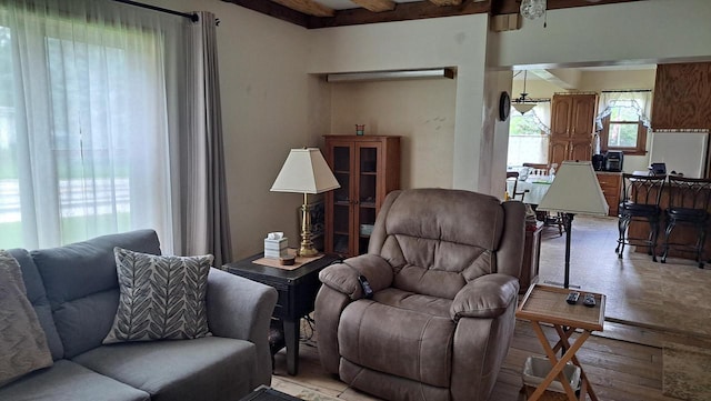 living area featuring beam ceiling and light wood-style flooring