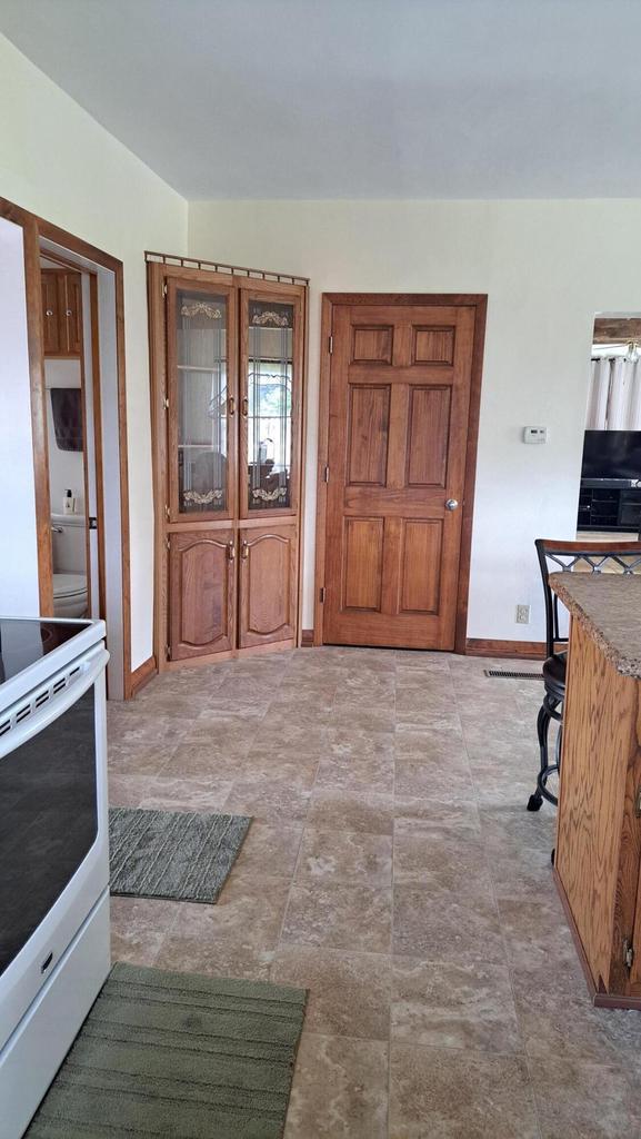 kitchen featuring white electric stove and baseboards