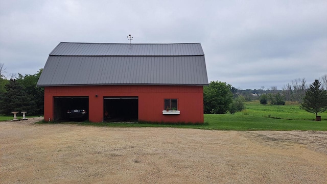 view of barn featuring a yard and dirt driveway